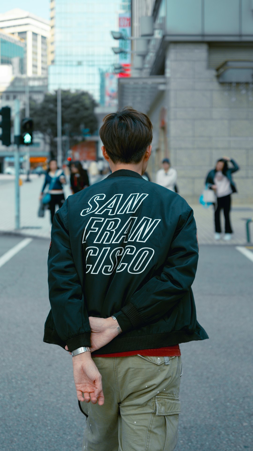 a-man-walking-down-a-street-with-a-jacket-on-udm2nnzdsmq