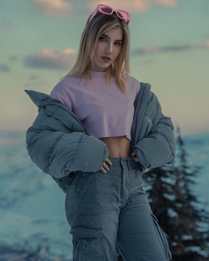 Stylish winter portrait of a woman in a snowy landscape with fashionable attire.